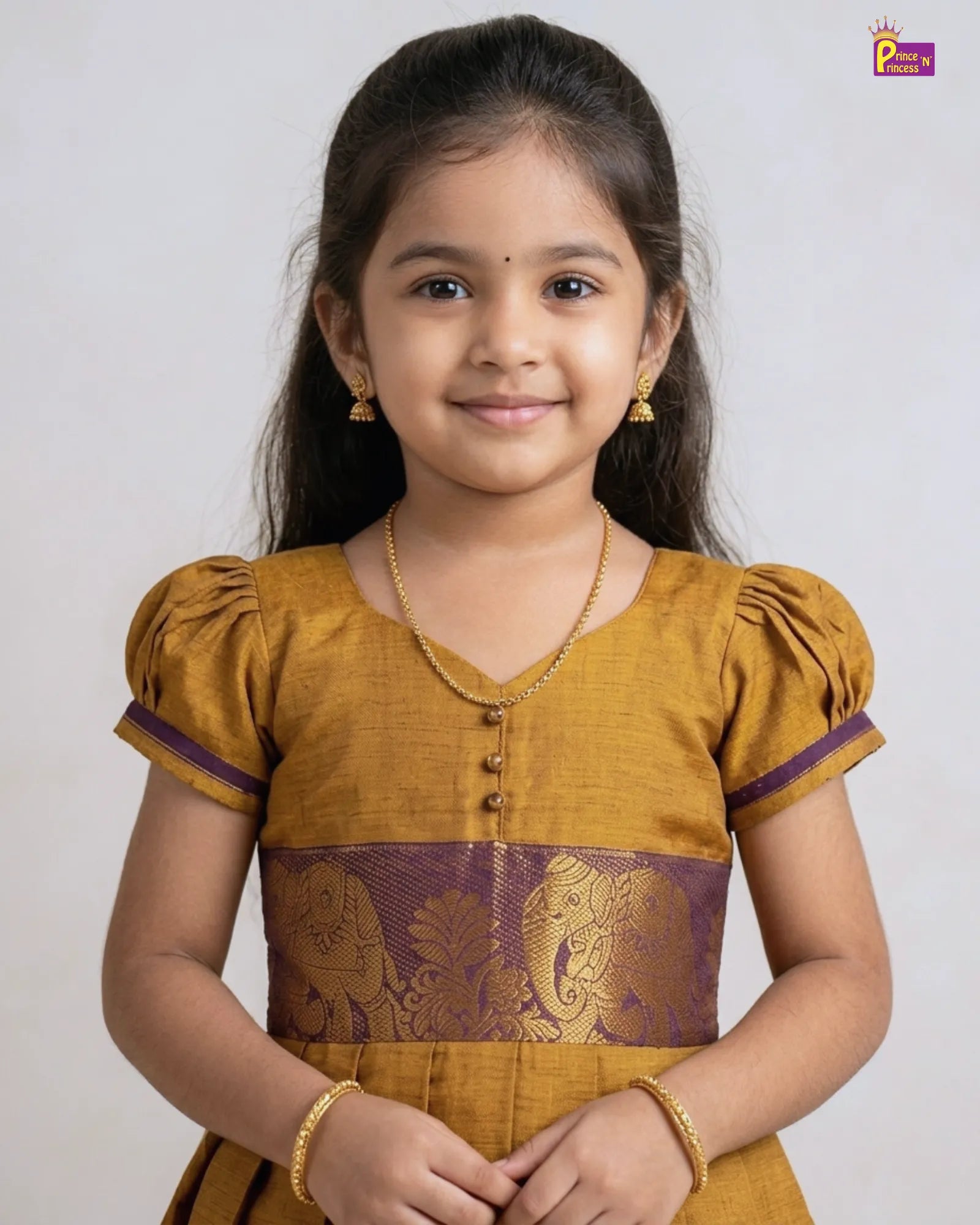 Young girl wearing a mustard yellow traditional outfit with purple accents on a white background