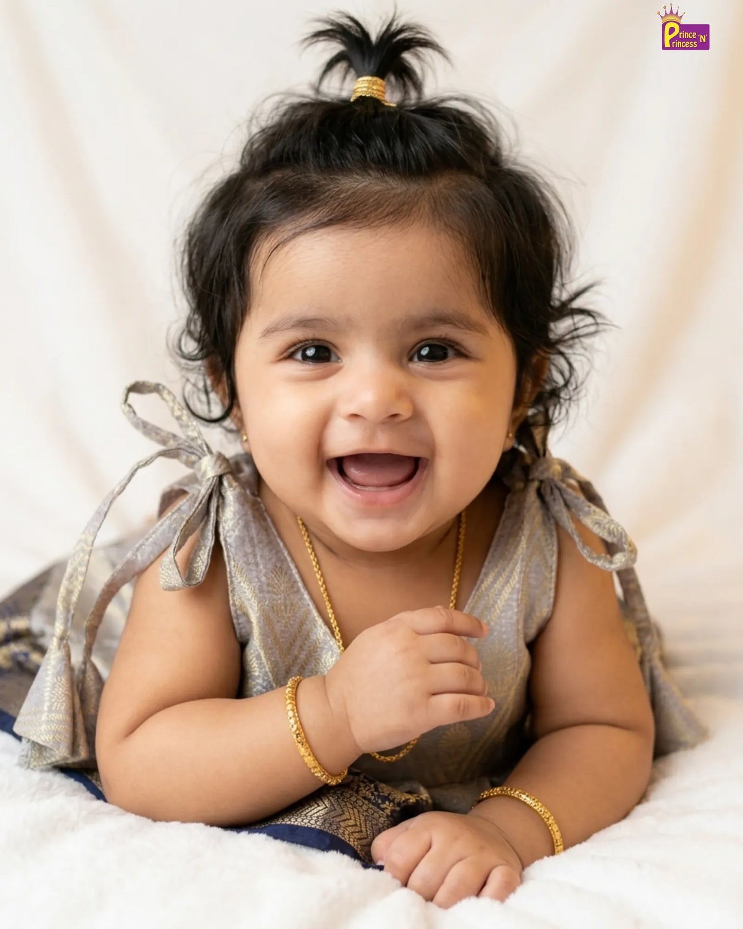 Happy baby with a gold bracelet on a white background