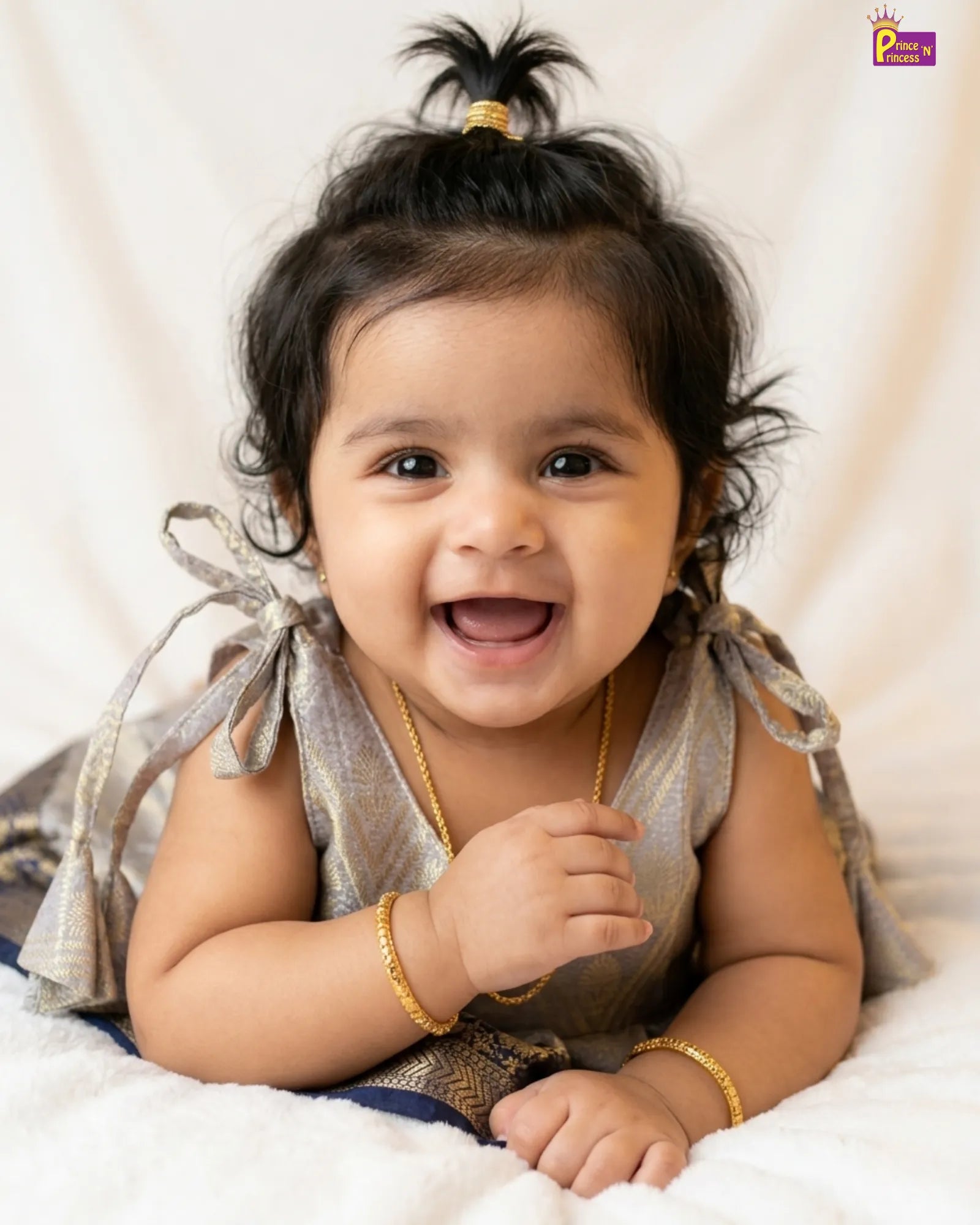 Happy baby with a gold bracelet on a white background