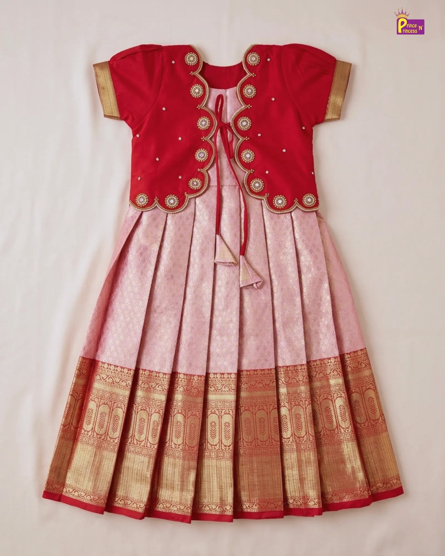 Red and pink traditional outfit with gold embroidery on a white background