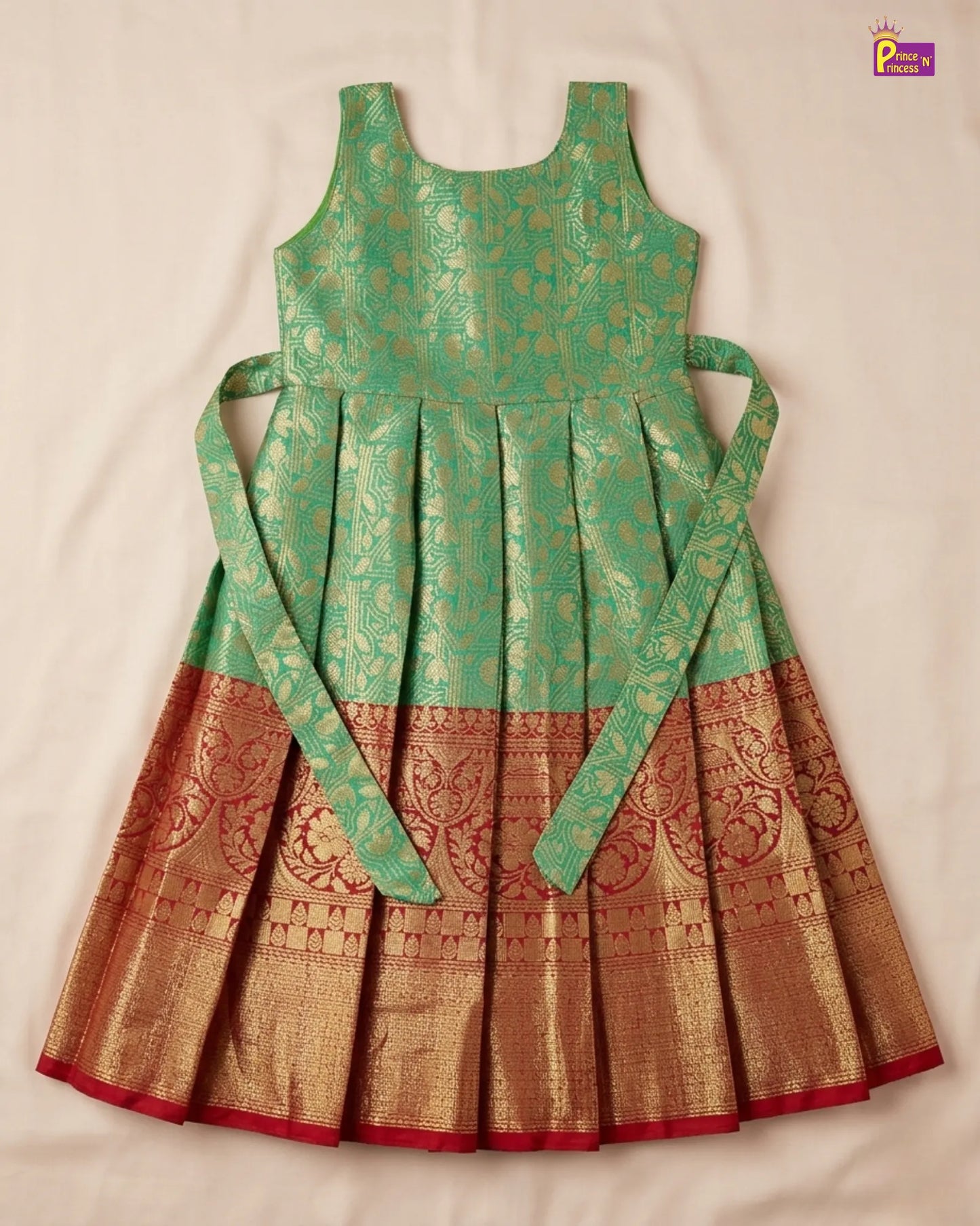 Green and brown traditional dress with intricate patterns on a beige background
