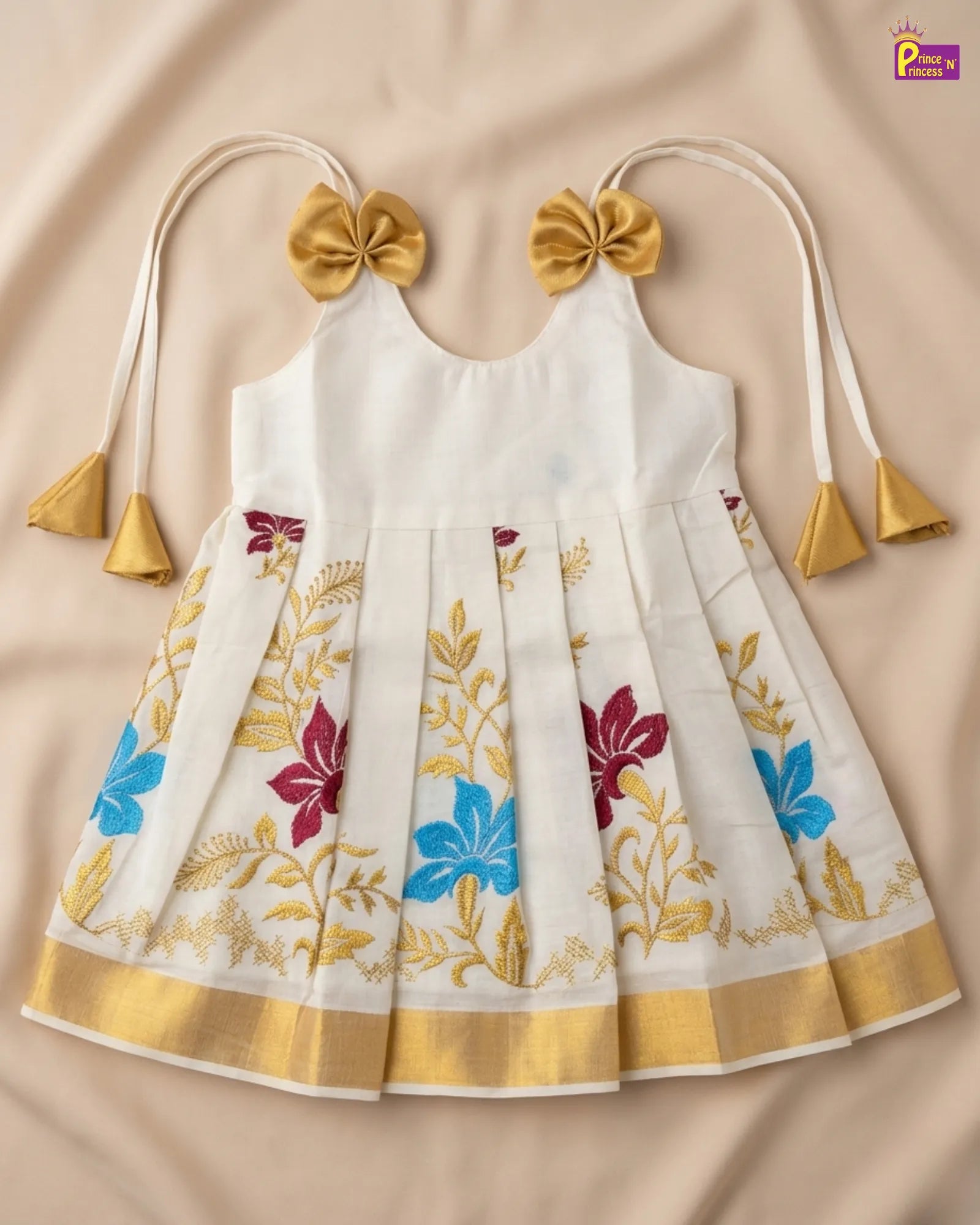 White dress with floral patterns and gold accents on a beige background
