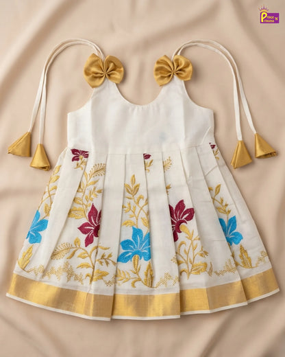 White dress with floral patterns and gold accents on a beige background