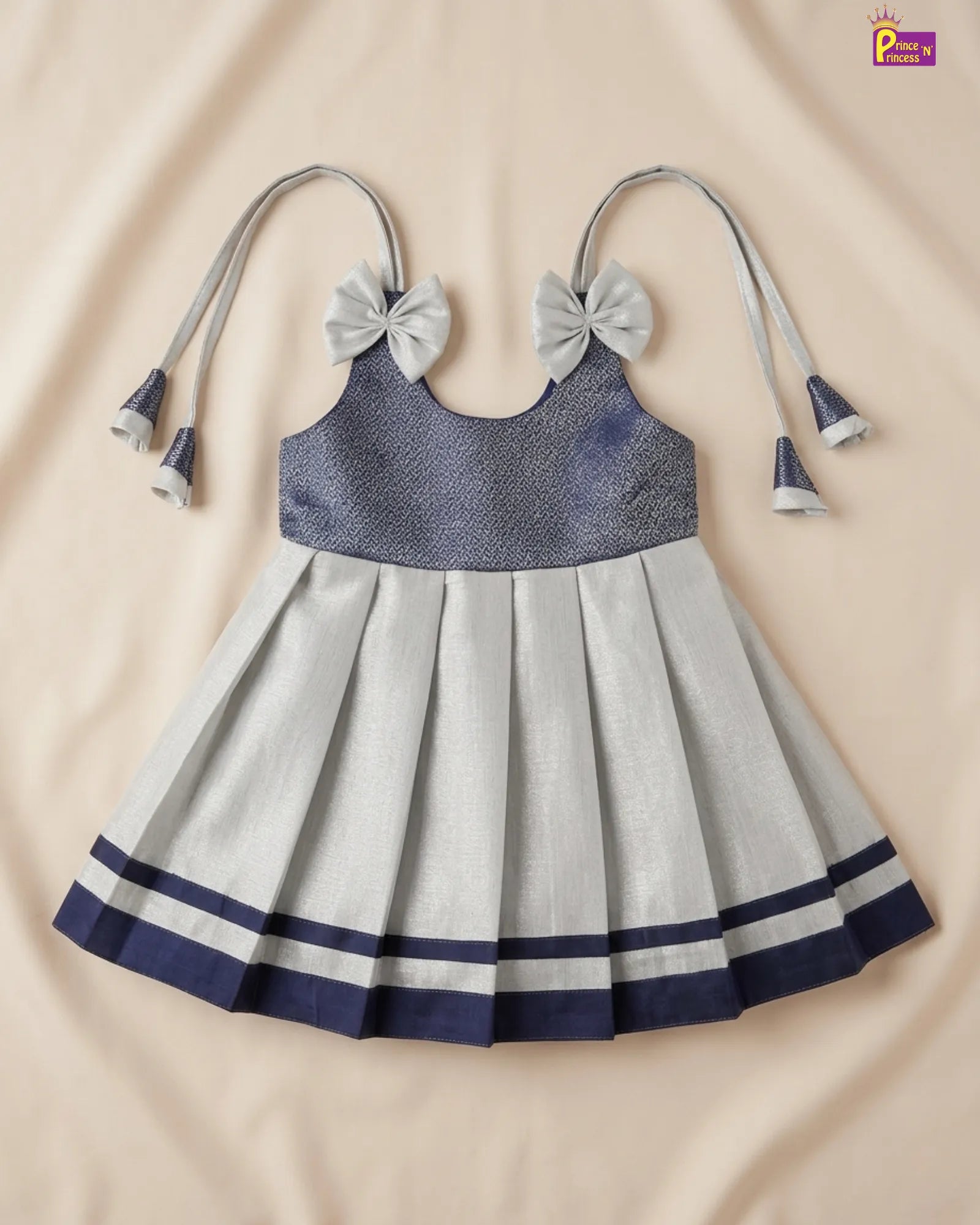Children's dress with blue top and gray skirt on a beige background