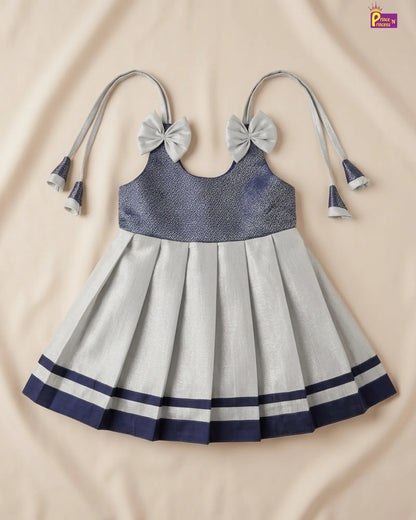 Children's dress with blue top and gray skirt on a beige background