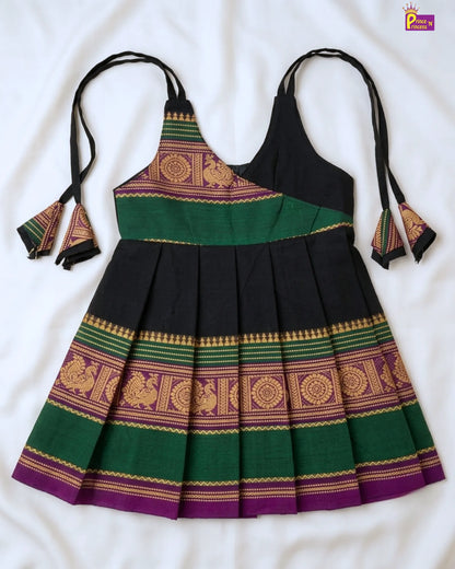 Traditional dress with green, purple, and gold patterns on a white background