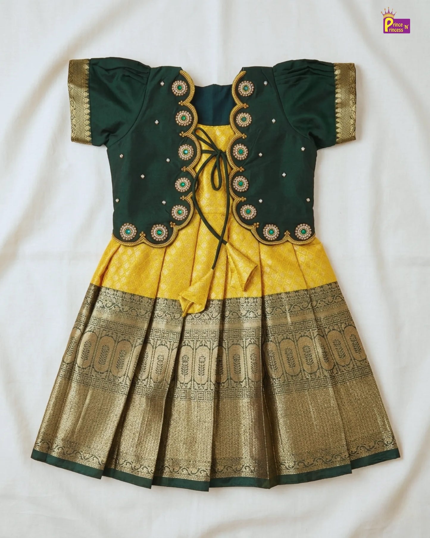 Green and yellow traditional outfit with intricate patterns on a white background