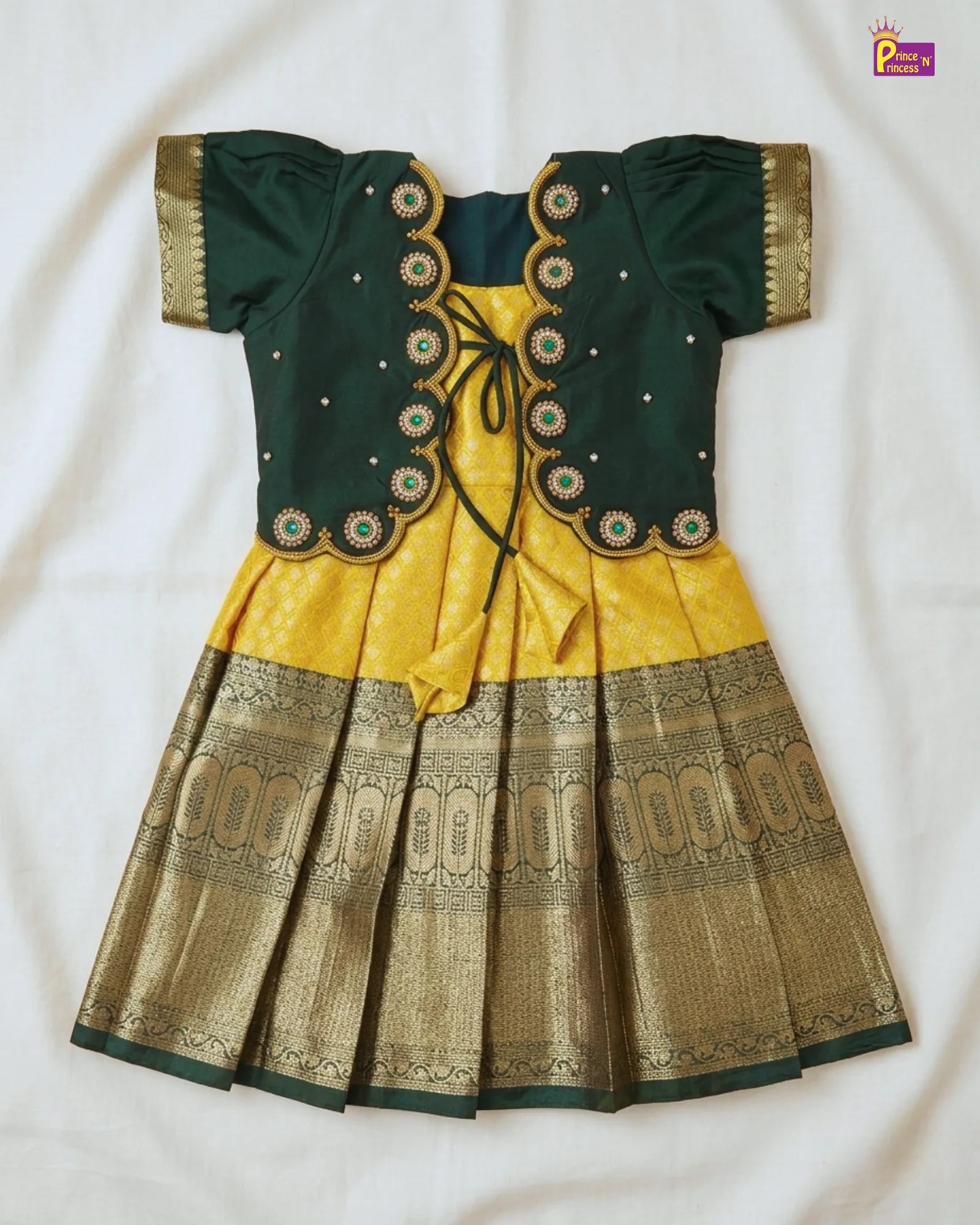 Green and yellow traditional outfit with intricate patterns on a white background