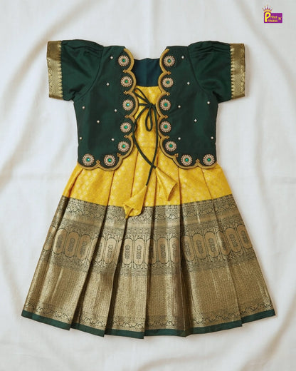 Green and yellow traditional outfit with intricate patterns on a white background