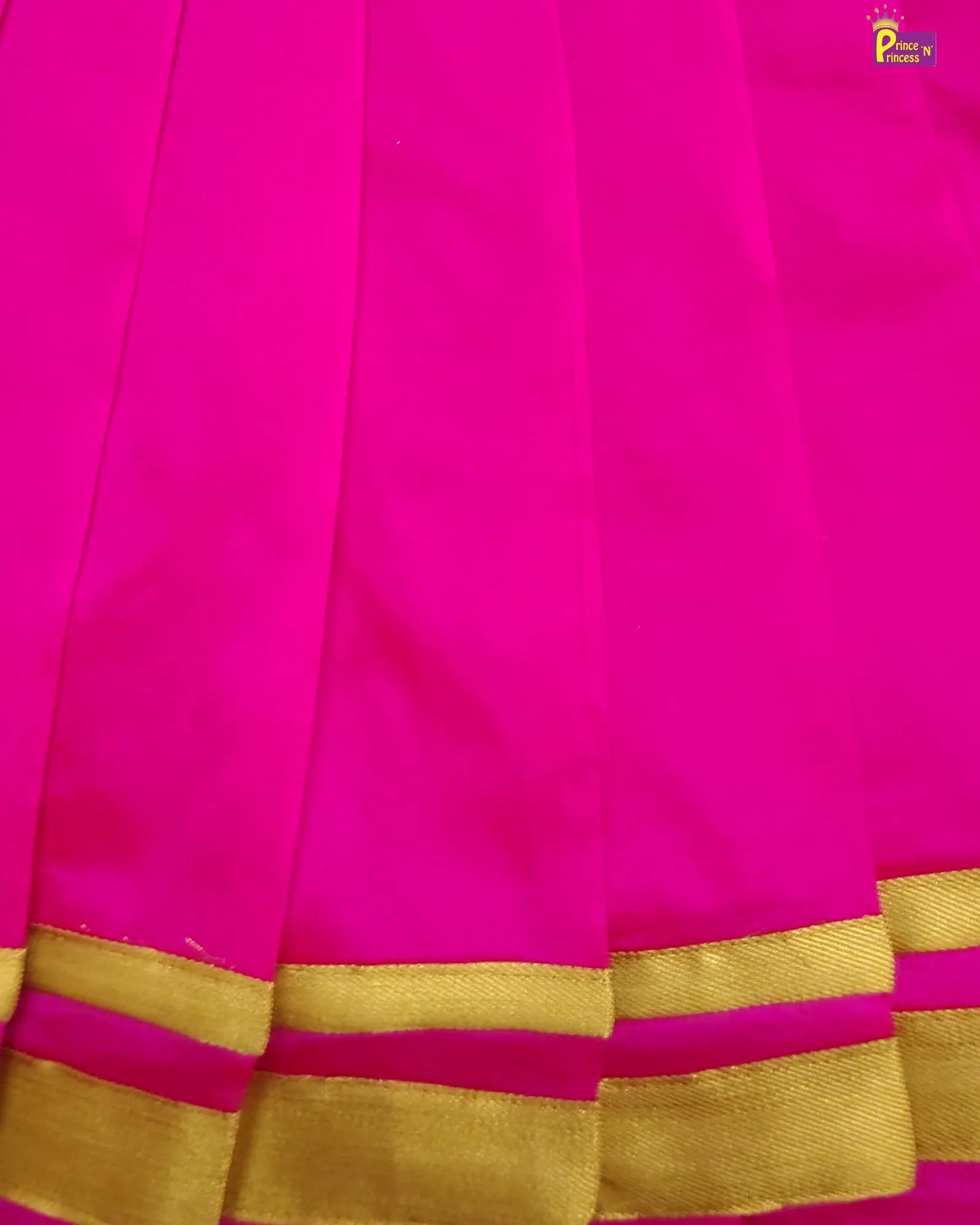 Close-up of a pink saree with gold border