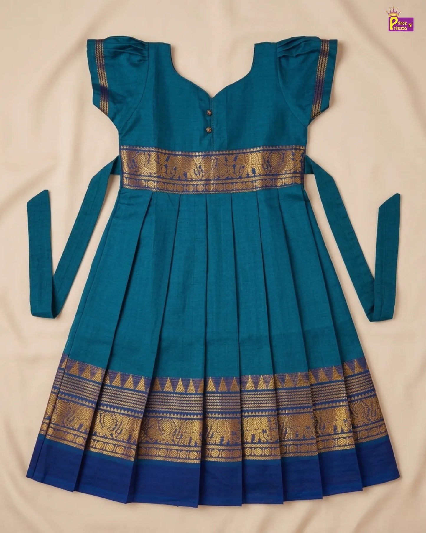 Teal dress with gold elephant patterns on a beige background