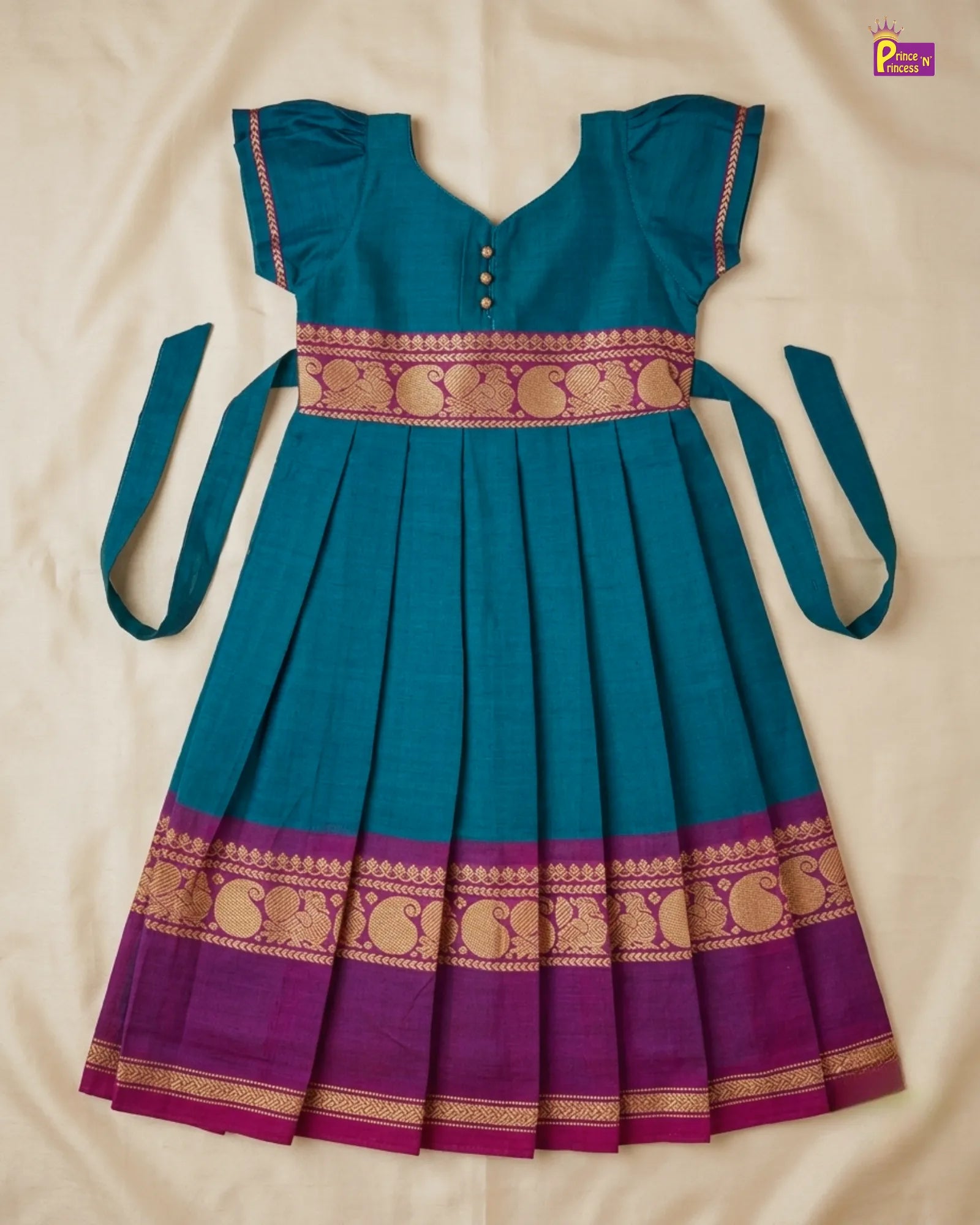 Teal and purple traditional dress with gold patterns on a beige background