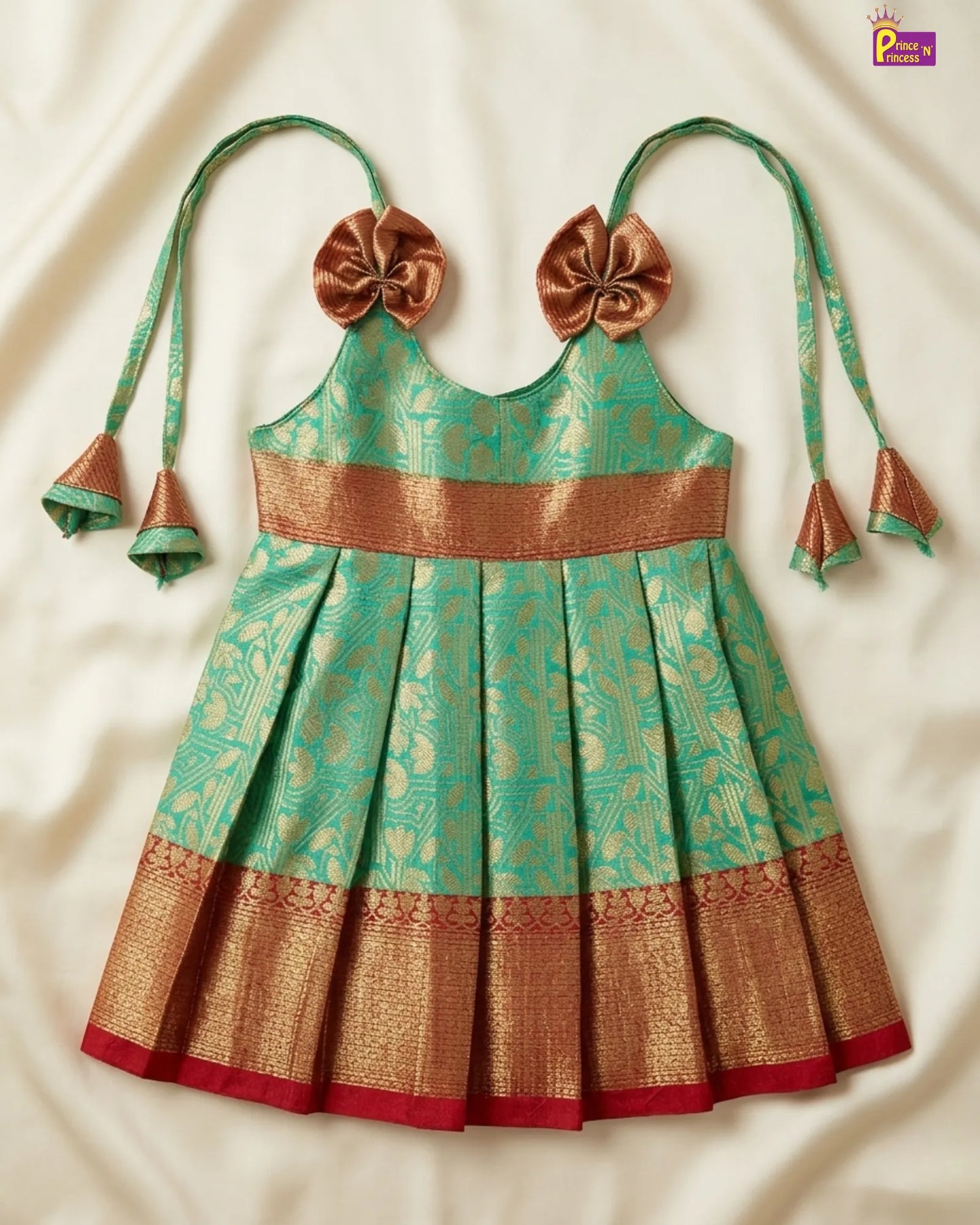 Traditional green and gold dress with decorative bows on a white background