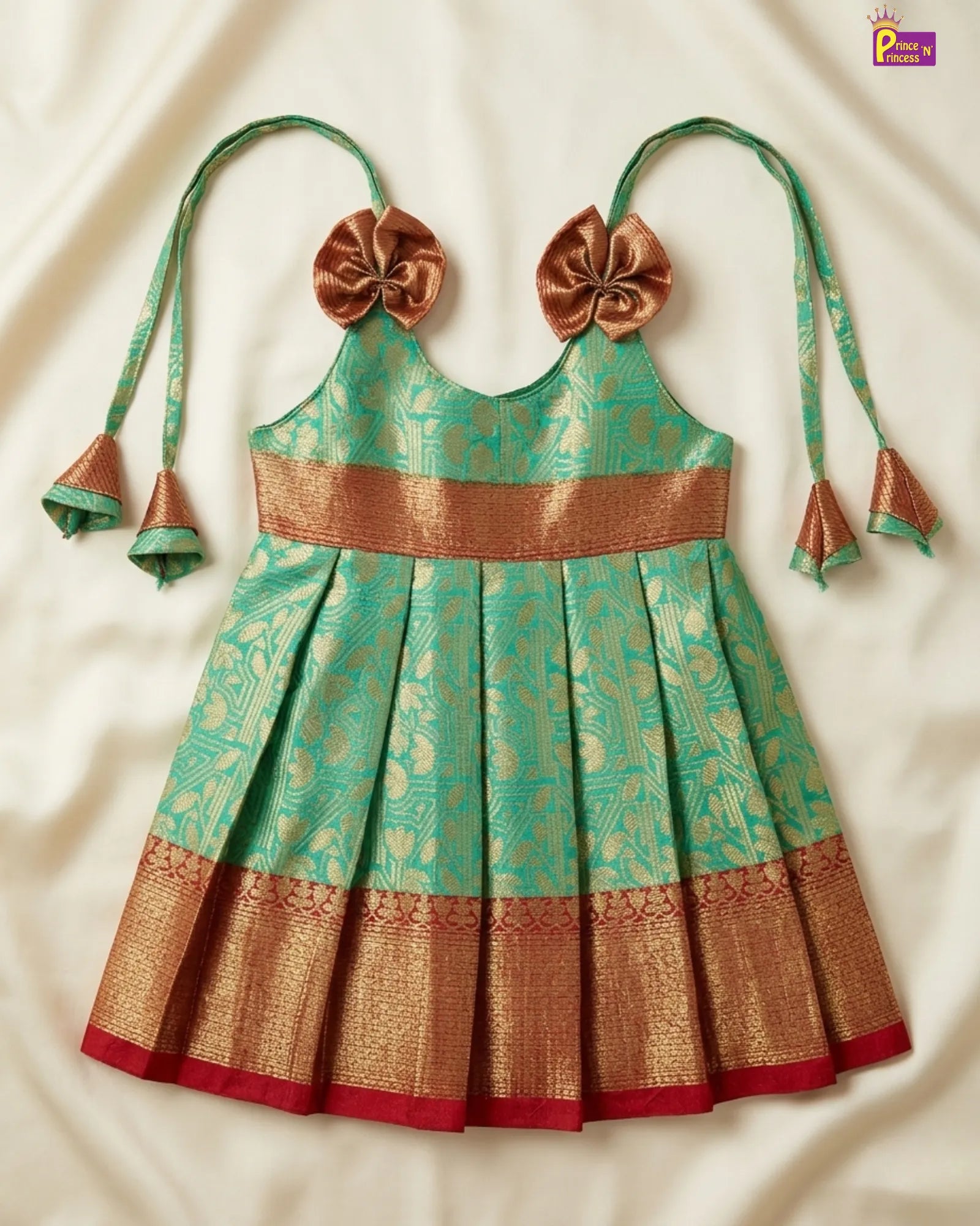 Traditional green and gold dress with decorative bows on a white background