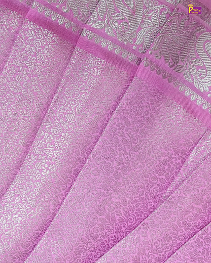Close-up of pink fabric with intricate patterns and a brand logo in the corner.