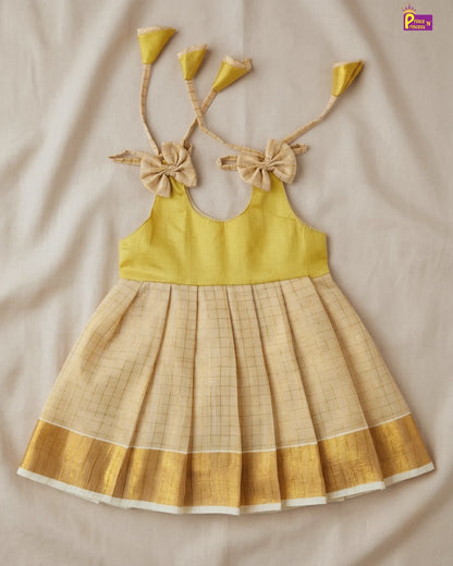 Yellow top and plaid skirt set with decorative straps on a beige background