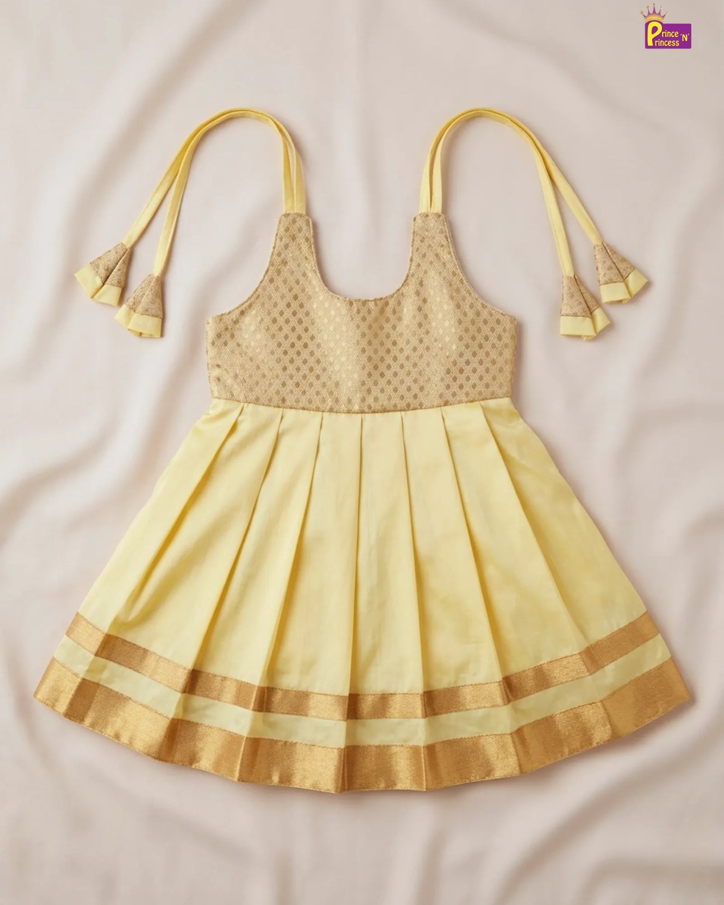 Yellow dress with pleated skirt and decorative straps on a beige background