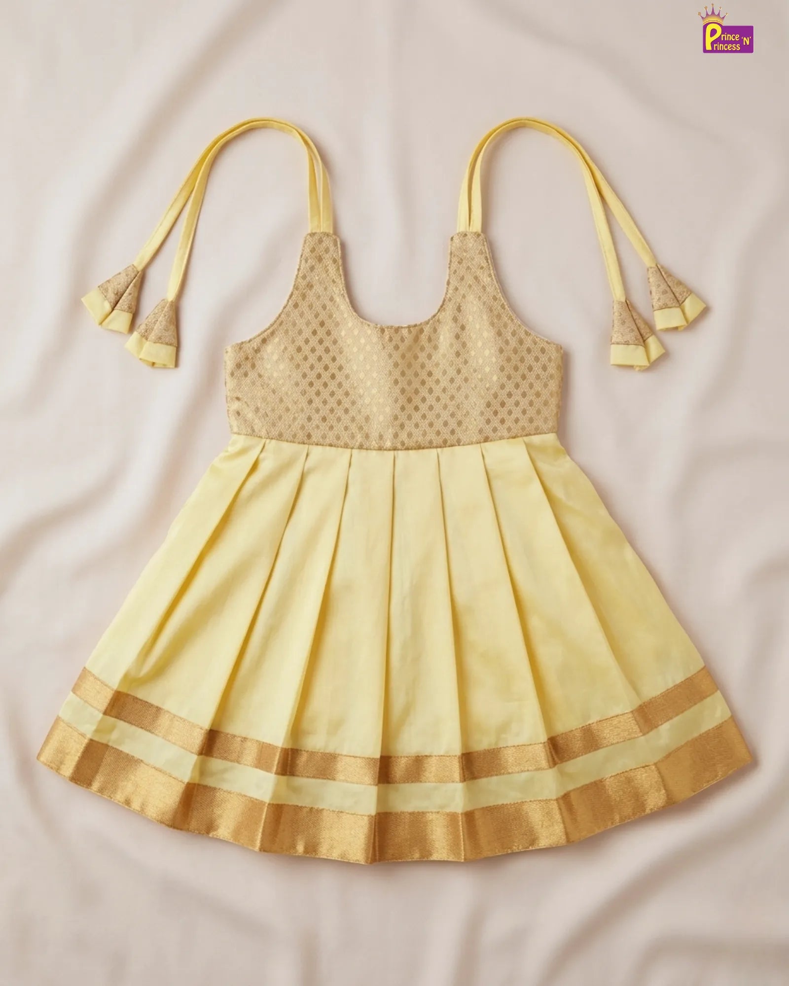 Yellow dress with pleated skirt and decorative straps on a beige background