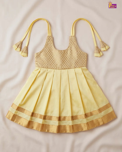 Yellow dress with pleated skirt and decorative straps on a beige background