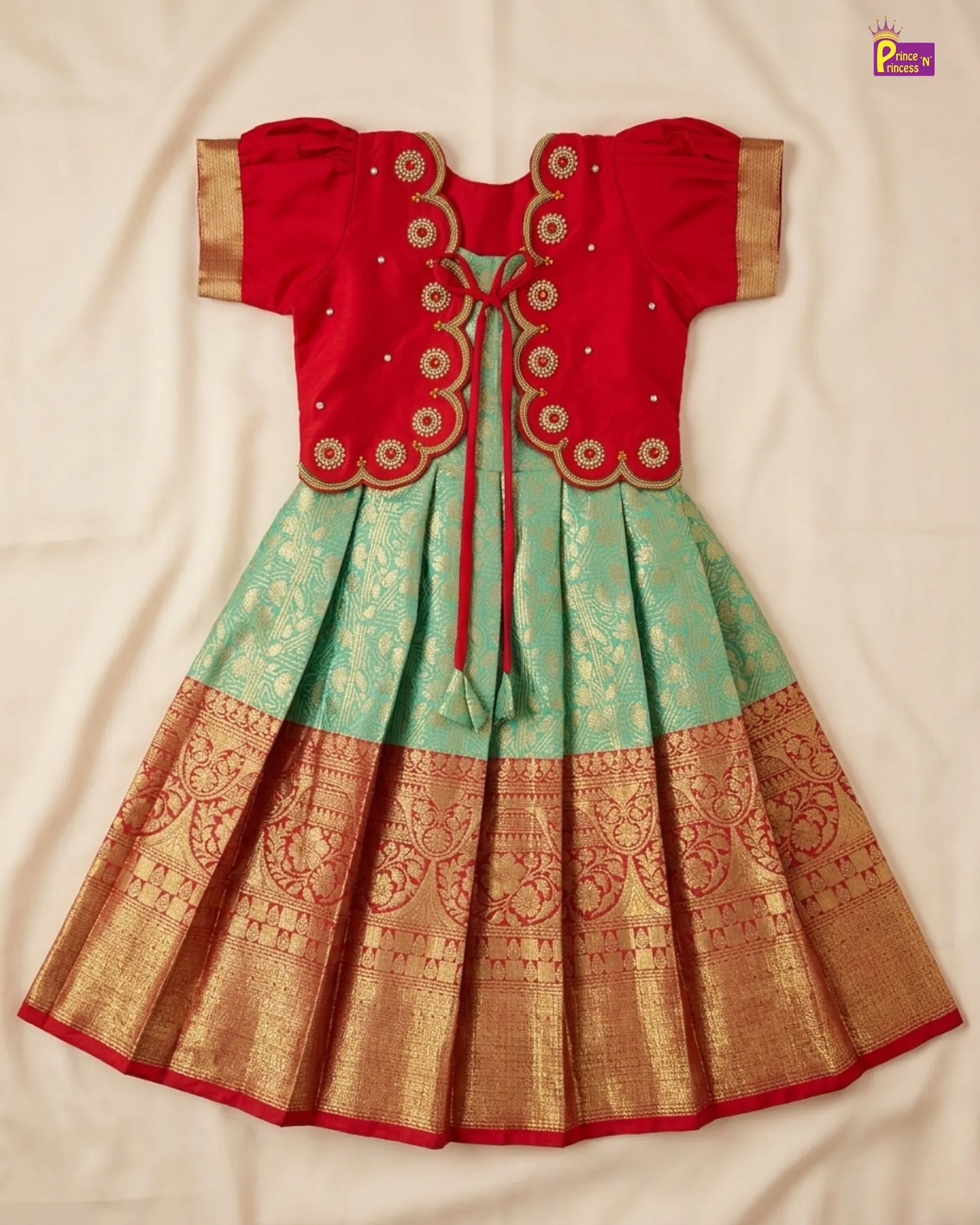 Traditional red and green dress with gold embroidery on a beige background