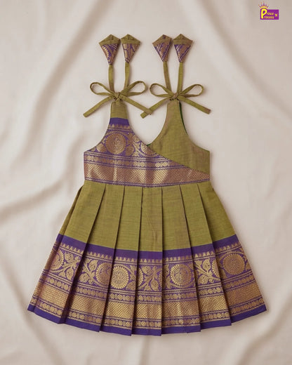 Green and purple traditional dress with intricate patterns on a beige background