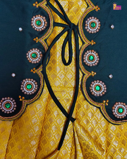 Close-up of a yellow fabric with black ribbon and decorative circular patterns on a dark background.