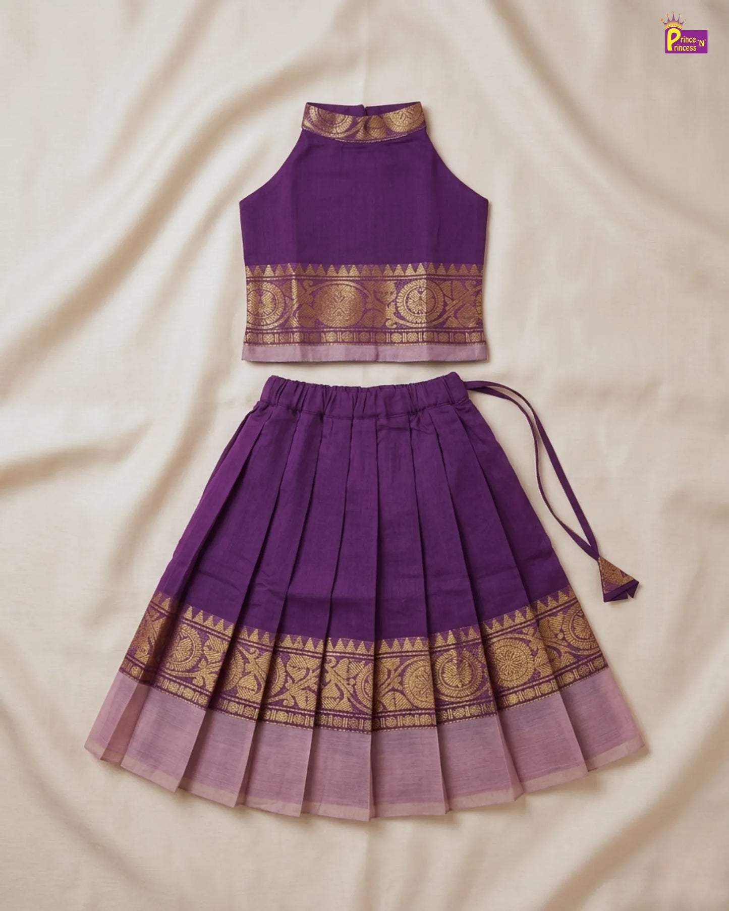 Purple traditional outfit with gold patterns on a beige fabric background