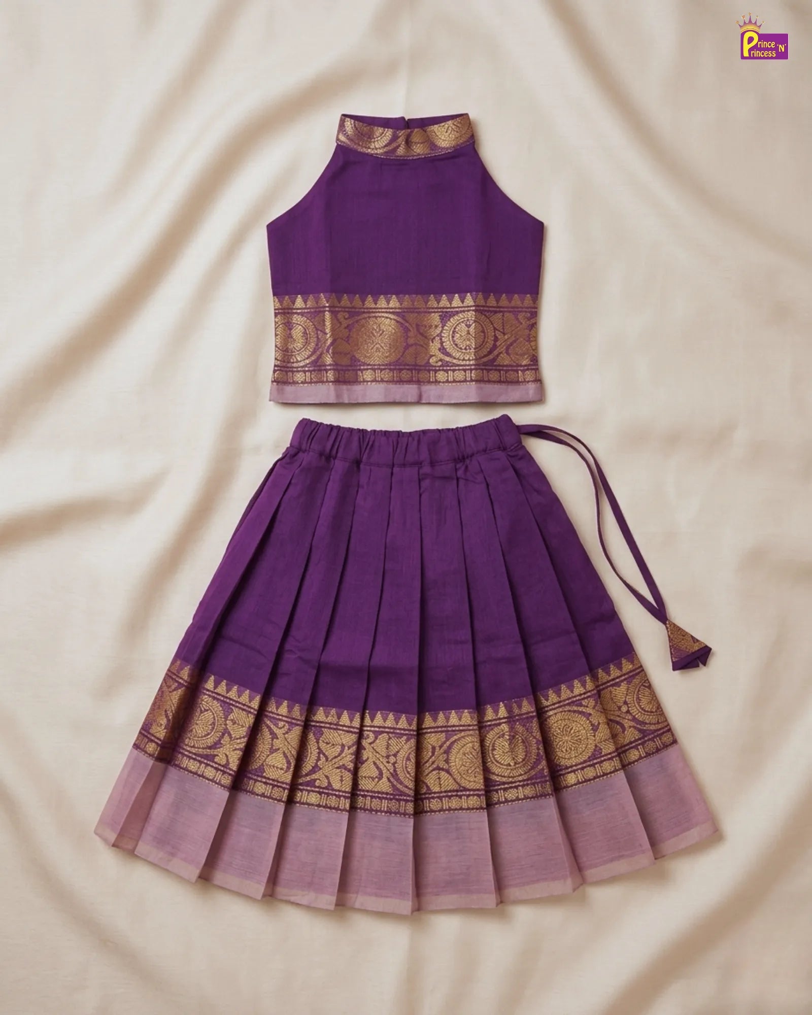 Purple traditional outfit with gold patterns on a beige fabric background