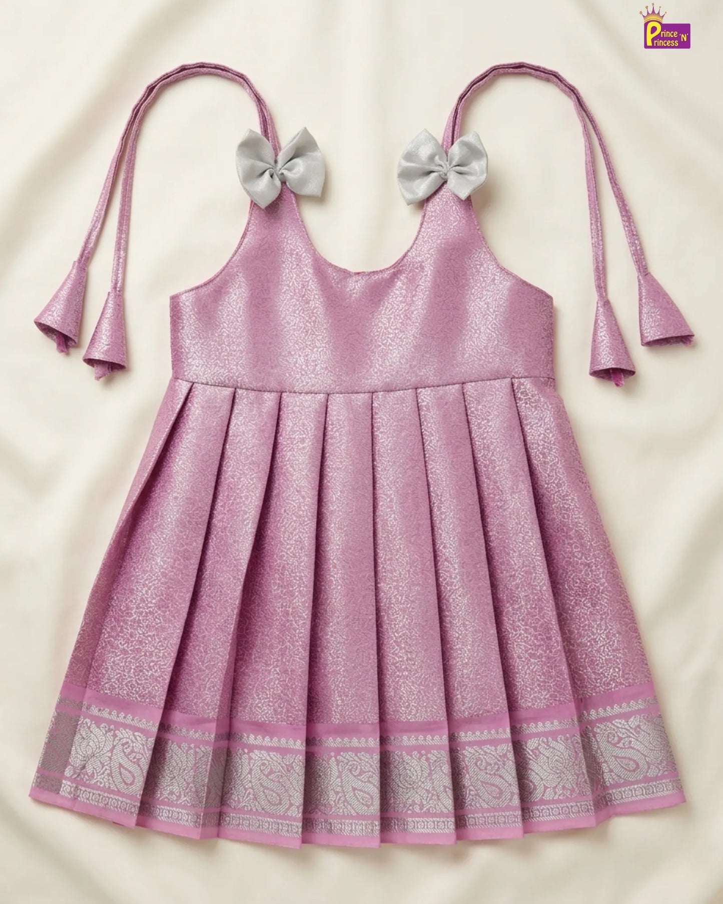Pink dress with silver bows and patterns on a beige background