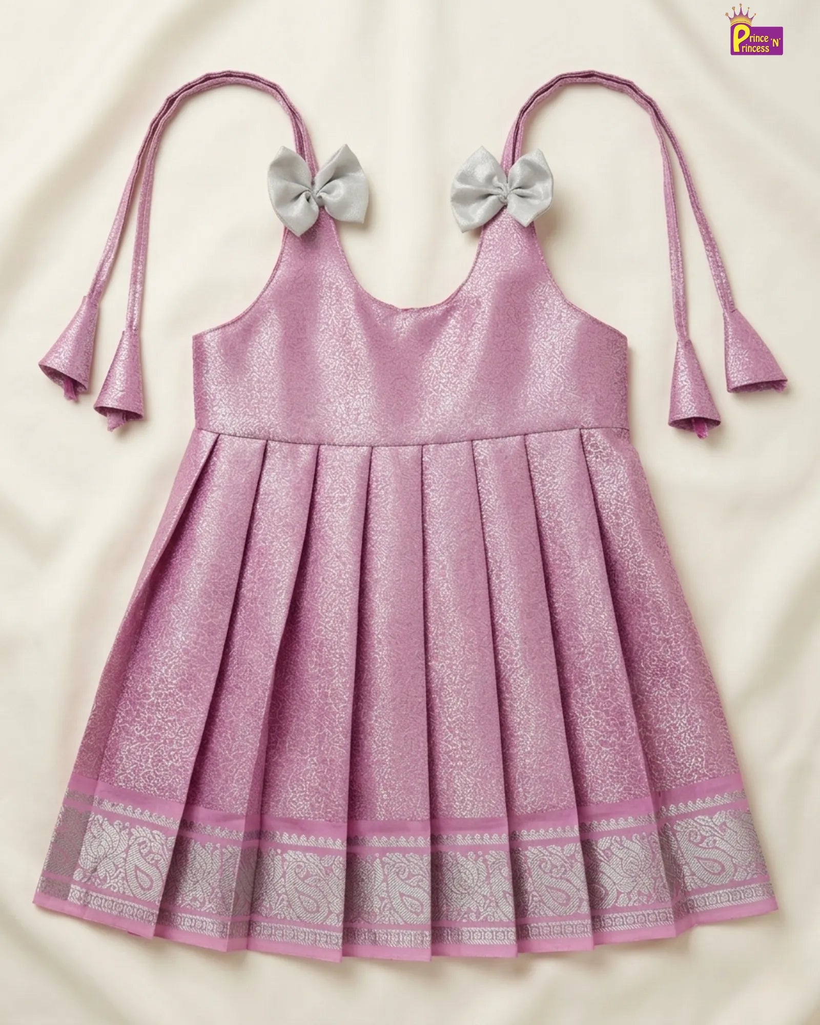 Pink dress with silver bows and patterns on a beige background