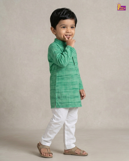 Child wearing a green kurta with white pants on a beige background