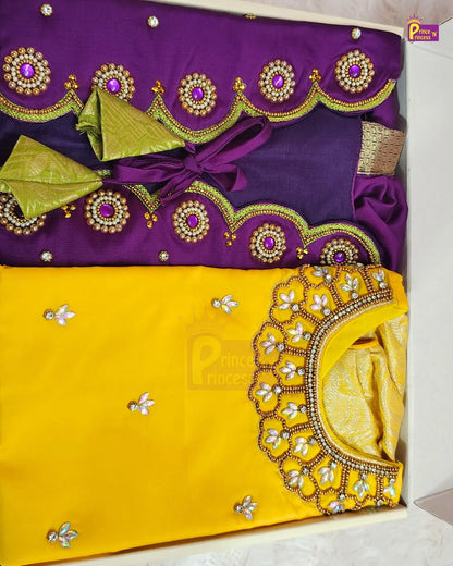 A folded traditional Indian ethnic wear set, featuring a purple and yellow fabric kurta set with intricate gold and silver embroidery, a matching yellow dupatta, and a small gold accessory, presented in a light-colored box.