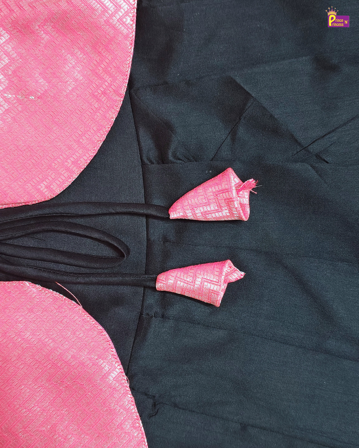 Black garment with pink floral patterns on a pink background