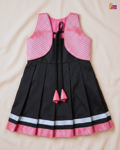 Black dress with pink and white patterned top on a beige background