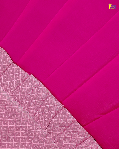 A close-up of a bright pink fabric with a lighter pink patterned border along the bottom left, showing the textile's texture and weave.