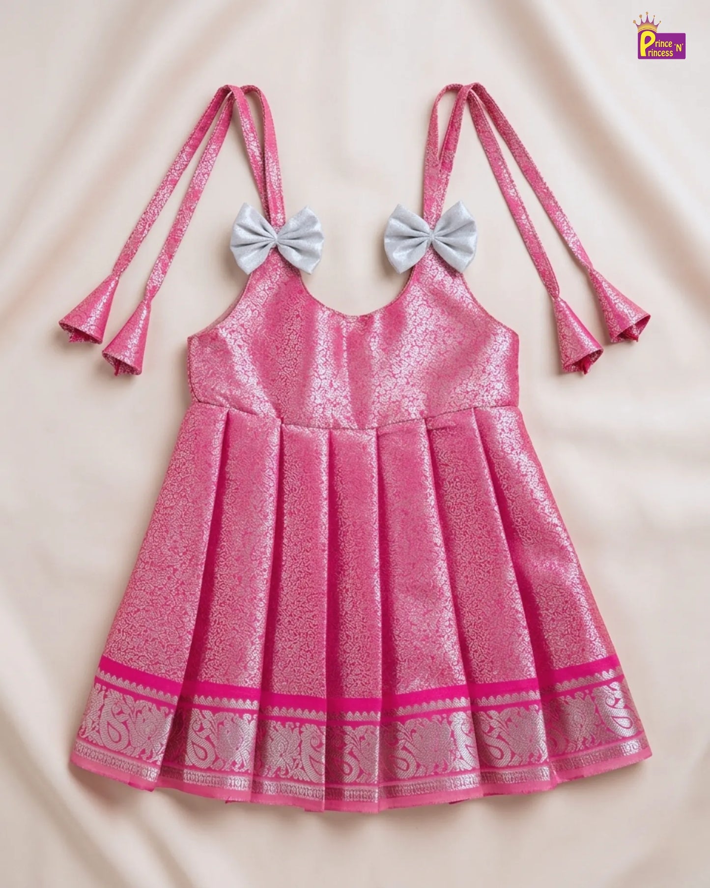 Pink dress with decorative bows on a beige background