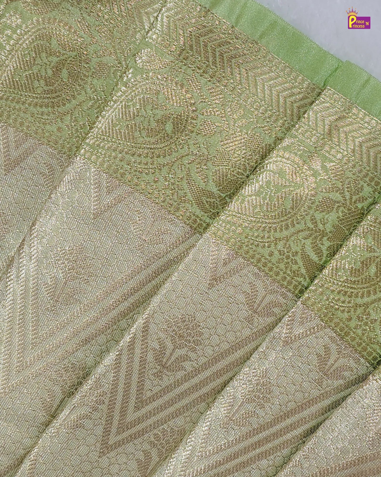 Close-up of a green and beige patterned fabric with intricate designs.