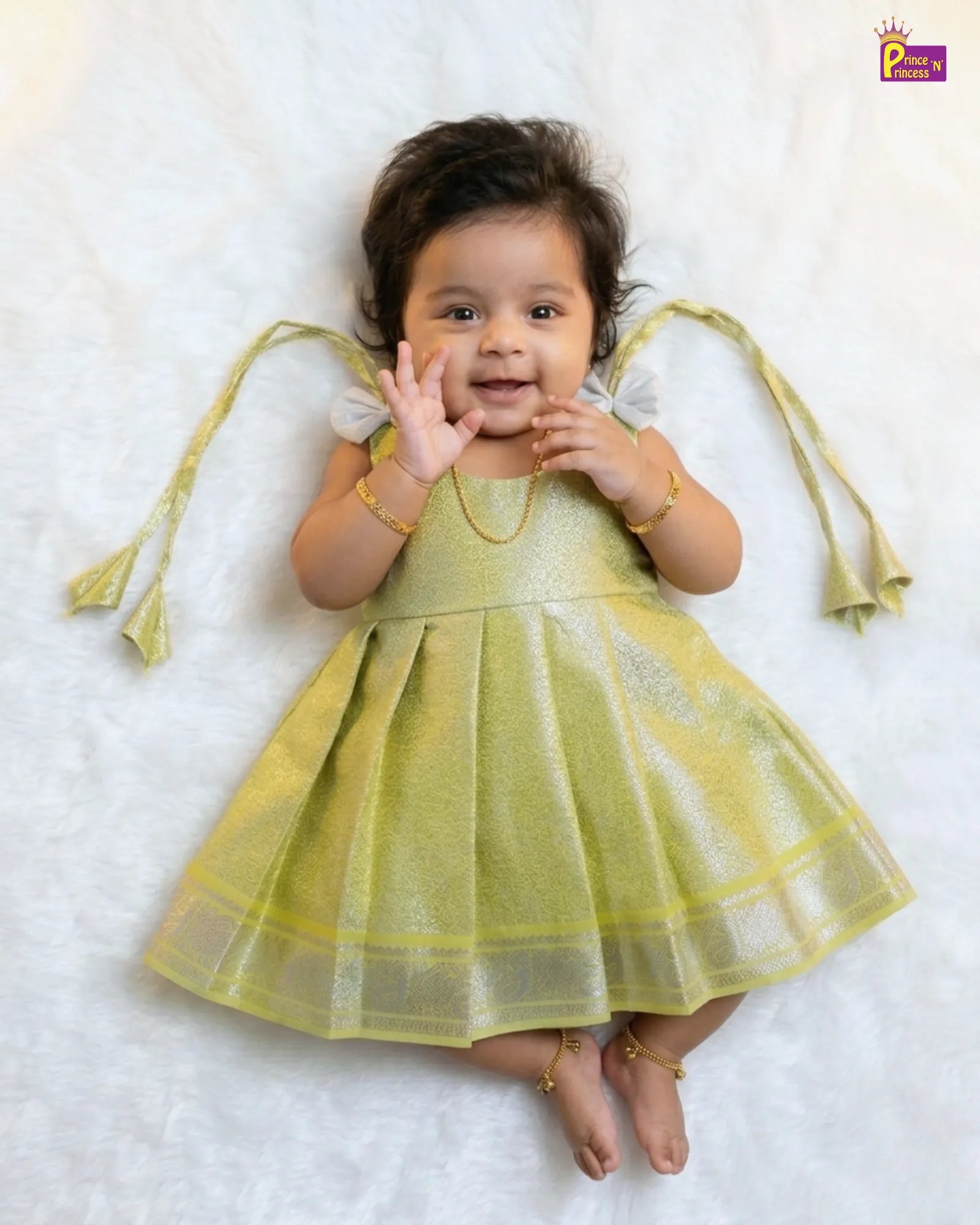 Baby in a yellow dress with angel wings on a white background