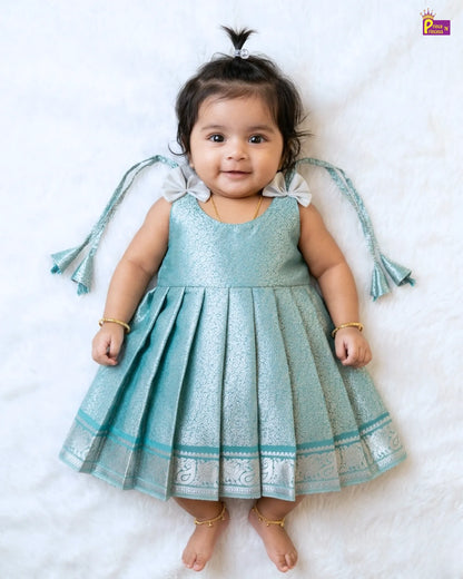 Baby in a light blue dress with decorative elements on a white background