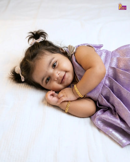 Young girl in a purple dress lying on a white surface