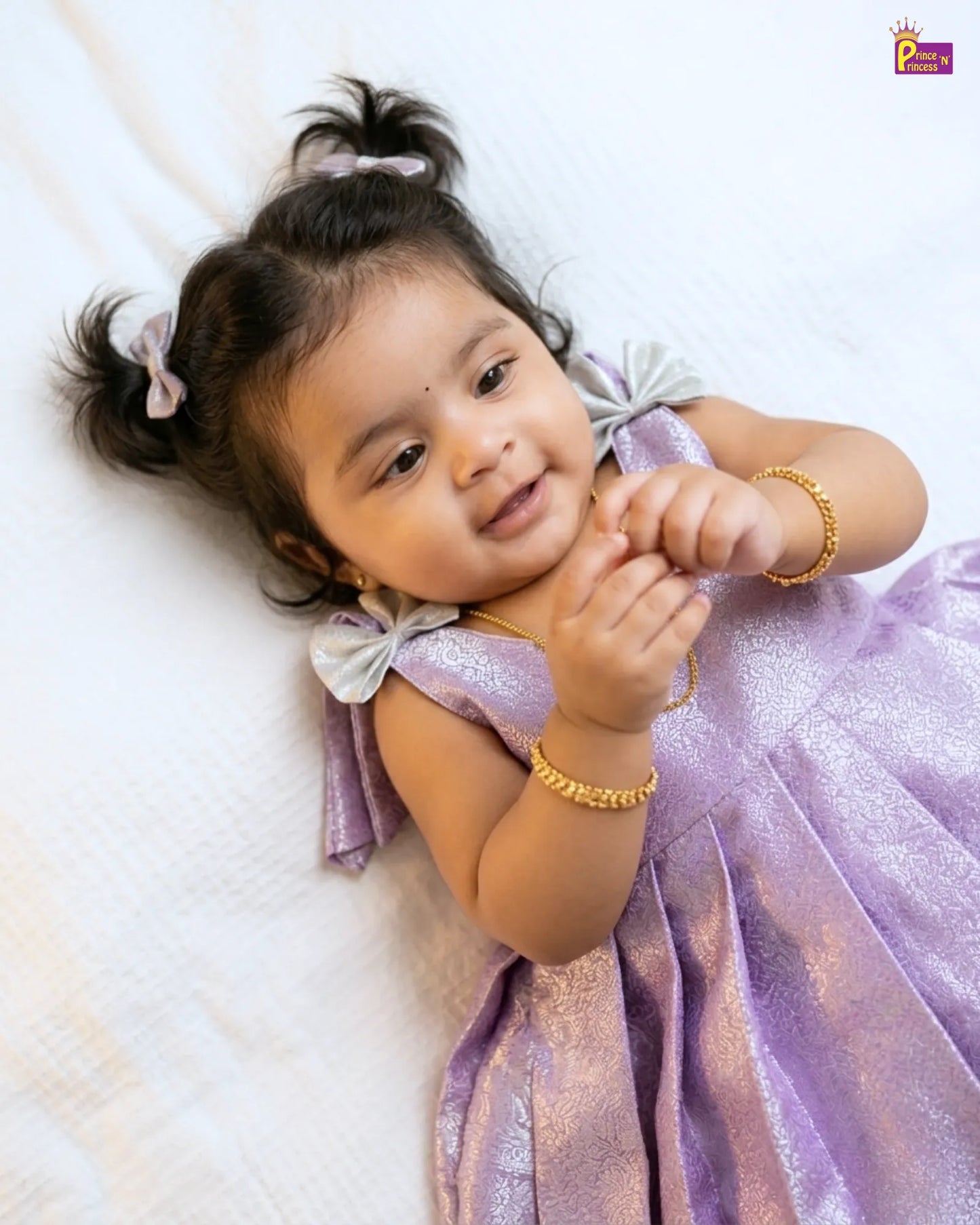 Child in a purple dress lying on a white surface