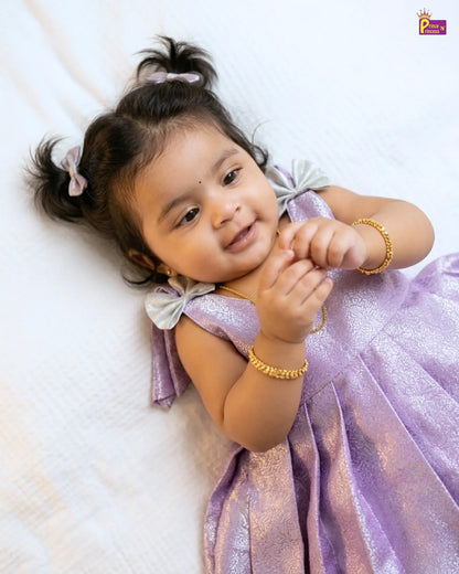 Child in a purple dress lying on a white surface
