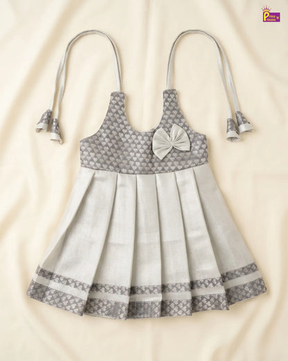 Gray and white patterned dress with bow detail on a beige background