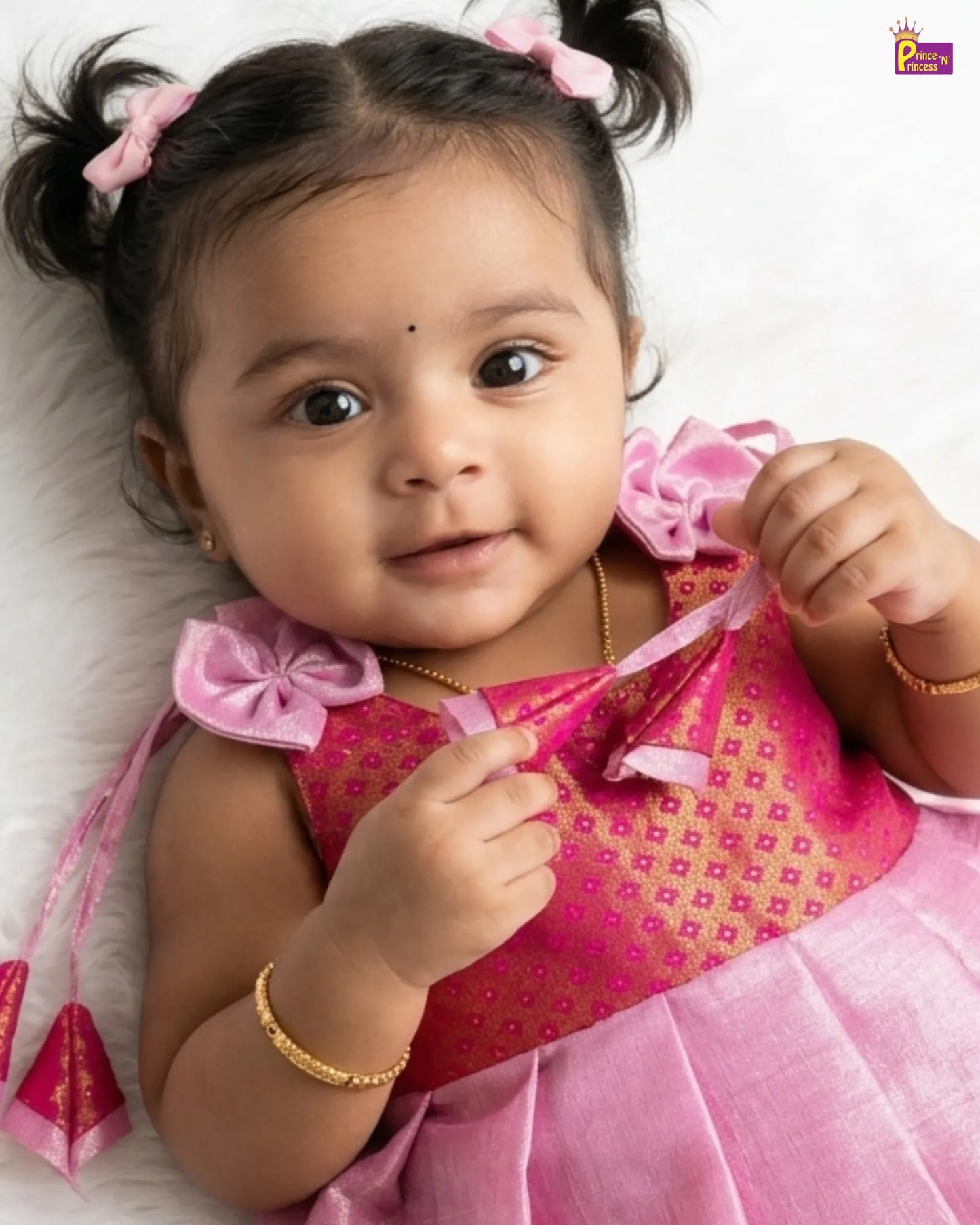 Baby in a pink dress with decorative elements on a white background