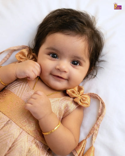 Baby wearing a gold outfit with a white background