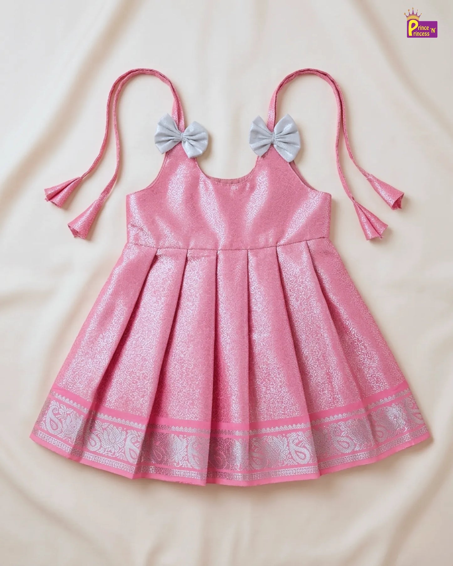 Pink dress with bow straps on a beige background