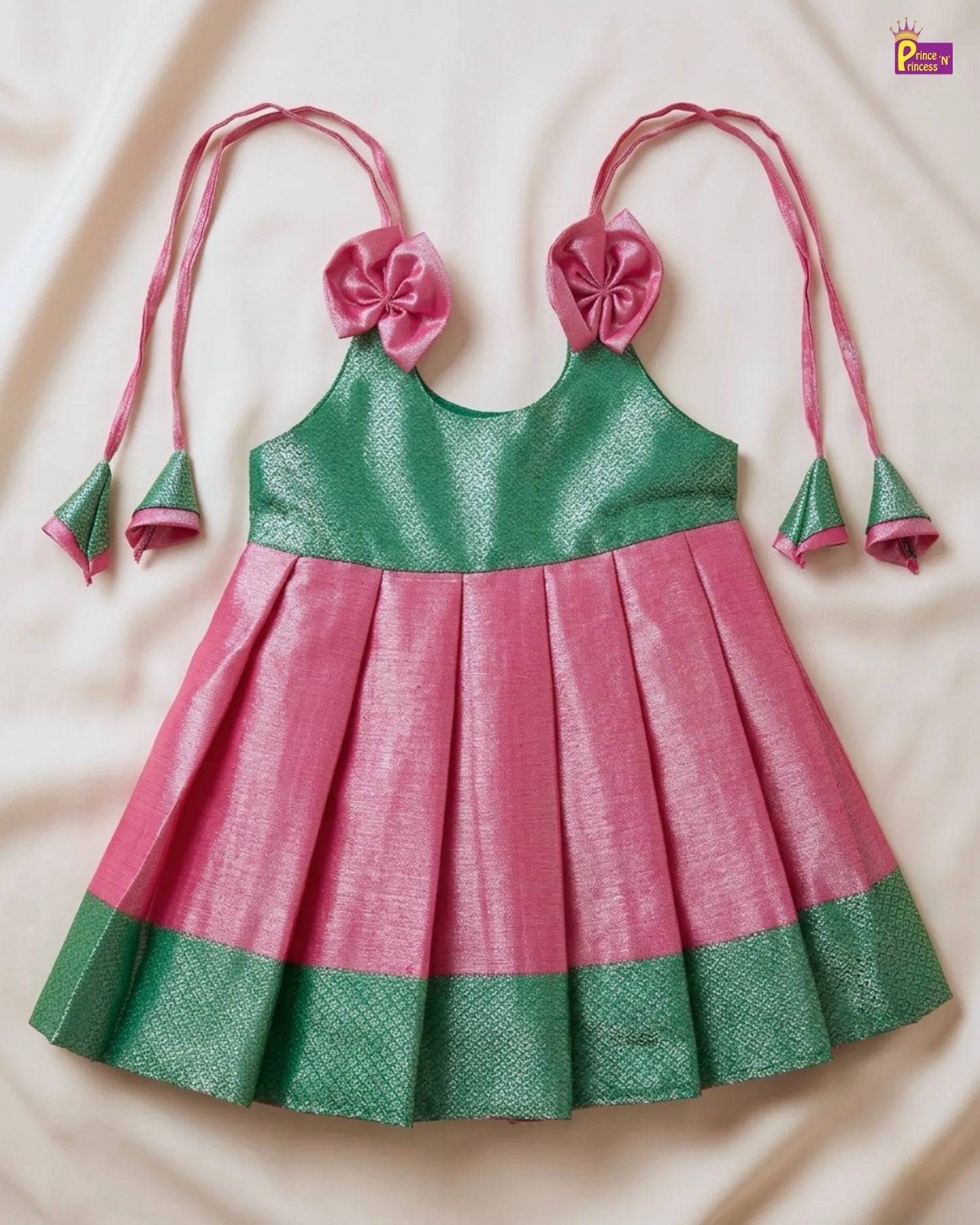 Green and pink dress with floral straps on a beige background