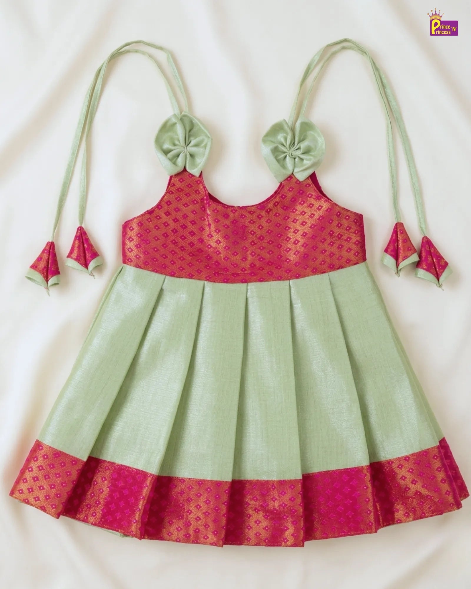Green and pink traditional outfit with floral details on a white background