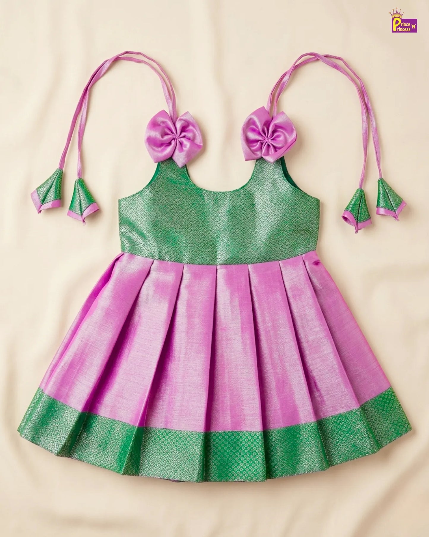 Green and pink children's dress with floral headbands on a beige background