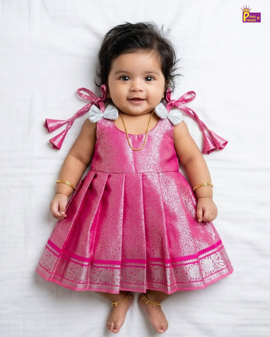 Child wearing a traditional dress with floral embellishments on a plain background